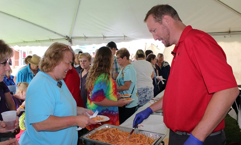 This photo shows a male serving food at the food festival