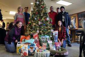 This photo shows students around a Christmas tree with donations