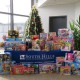 This photo shows a Christmas tree and a table full of toy donations