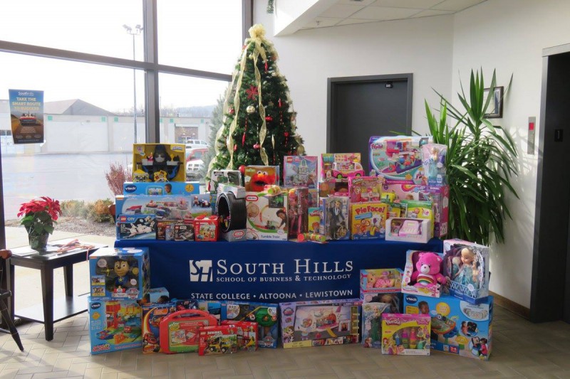 This photo shows a Christmas tree and a table full of toy donations