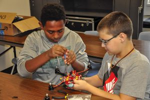 Two PA Cyber Charter Schools students are shown as they assemble a RubiQ racing drone.