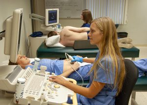 This photo shows sonography students in a medical lab practicing.