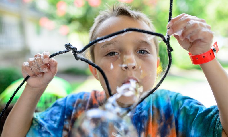 This photo shows a child blowing bubbles