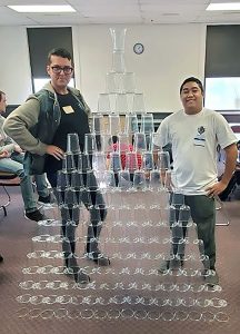 Information Technology students, Jarrod Frederick and Scott Goss, show off their project during the cup-stacking activity. This challenge pushed participants to use analytical skills to build the tallest tower in the shortest amount of time. Although this was not directly related to building hardware or software, strategic thinking and a problem-solving mindset was needed to win.