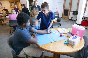 Students of the Medical Assistant specialized associate degree program are shown practicing venipunctures.