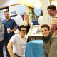 This photo shows smiling students holding a cake